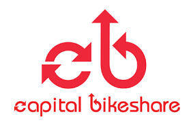 Red "capital bikeshare" logo with stylized lowercase "c" and "b" forming arrows, and the text "capital bikeshare" below in matching red font.