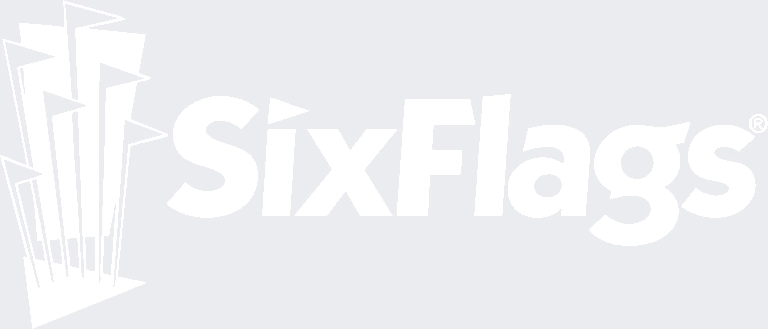 The image shows the Six Flags logo with six stylized flags on the left and the words "Six Flags" in bold letters to the right. The design is light gray on a white background.