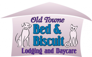 Logo for "Old Towne Bed & Biscuit Lodging and Daycare" featuring a cartoon dog and cat on each side of the text, with a house-shaped outline in the background.